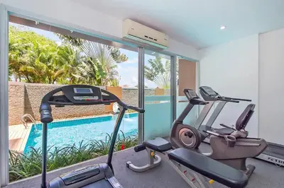 a gym with two exercise bikes and a swimming pool at Stylish Sea view Chic condo in Karon Beach