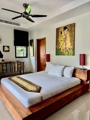 a bedroom with a large bed with a ceiling fan at Stunning 2-Bedroom Pool Villa in Ban Thalat Choeng Thale