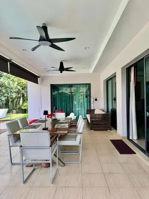 a dining room with a table and a ceiling fan at Stunning 2-Bedroom Pool Villa in Ban Thalat Choeng Thale