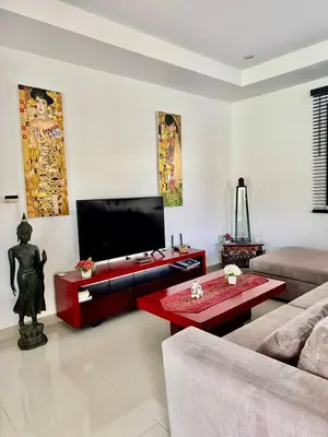 a living room with a couch and a tv at Stunning 2-Bedroom Pool Villa in Ban Thalat Choeng Thale
