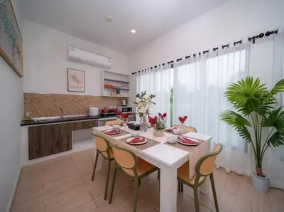 a dining room with a table and chairs and a kitchen at \u6cf0\u56fd\u666e\u5409\u5c9bYona\u6d77\u8fb9\u56db\u5367\u5ba43\u53f7 in Ban Bang La
