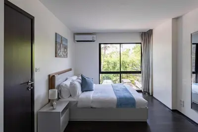 a bedroom with a bed and a large window at Rawai beach 1br apartment at The Title in Rawai Beach