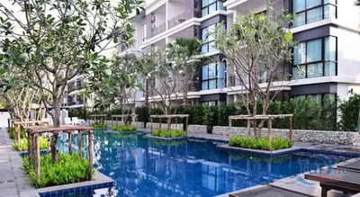 a swimming pool in front of a building at Rawai beach 1br apartment at The Title in Rawai Beach