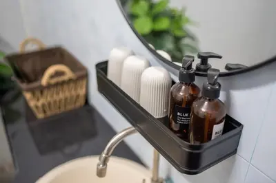 a bathroom sink with a soap dispenser and a mirror at Beachfront 4-BR House in Patong in Patong Beach