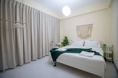 a bedroom with a large white bed with green sheets at Beachfront 4-BR House in Patong in Patong Beach