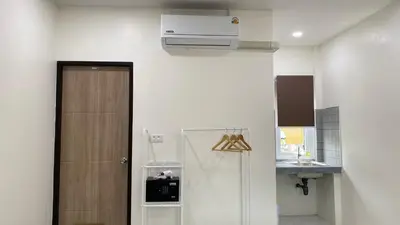 a small kitchen with a refrigerator and a sink at Suntalee House in Nai Yang Beach