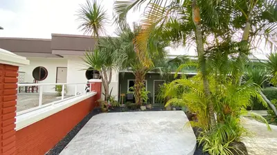 a courtyard with palm trees and a building at Suntalee House in Nai Yang Beach