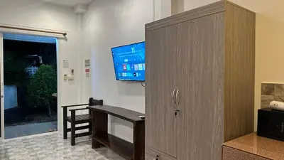 a room with a desk and a tv on a wall at Suntalee House in Nai Yang Beach