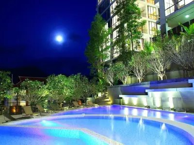 a large swimming pool at night with a building at Luxury 2-Bedroom Penthouse with Seaview Kamala in Kamala Beach