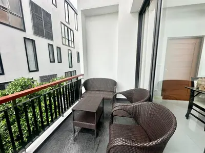 a balcony with wicker chairs and a table at Luxury 2-Bedroom Penthouse with Seaview Kamala in Kamala Beach