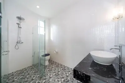 a bathroom with a sink and a glass shower at AP Nest Villas Residence - Tropical Pool Access, near Kamala Beach in Kamala Beach