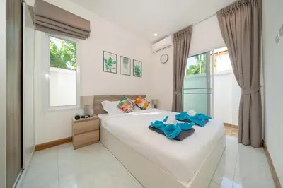 a bedroom with a white bed with blue towels on it at AP Nest Villas Residence - Tropical Pool Access, near Kamala Beach in Kamala Beach