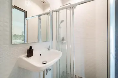 a white bathroom with a sink and a shower at AP Nest Villas Residence - Tropical Pool Access, near Kamala Beach in Kamala Beach