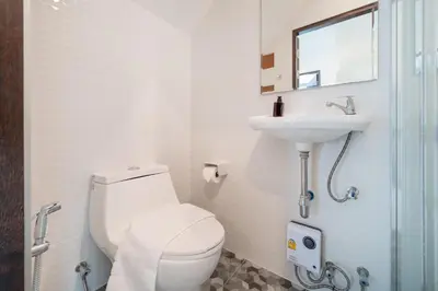 a white bathroom with a toilet and a sink at AP Nest Villas Residence - Tropical Pool Access, near Kamala Beach in Kamala Beach