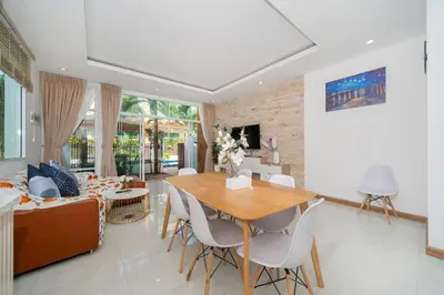 a living room with a table and a couch at AP Nest Villas Residence - Tropical Pool Access, near Kamala Beach in Kamala Beach