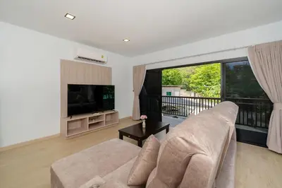 a living room with a couch and a large window at The Hideout Beachfront in Patong Beach