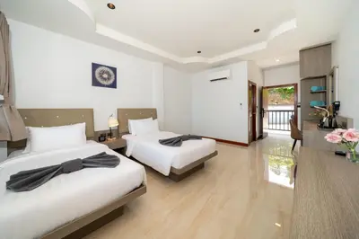 a hotel room with two beds and a balcony at The Hideout Beachfront in Patong Beach