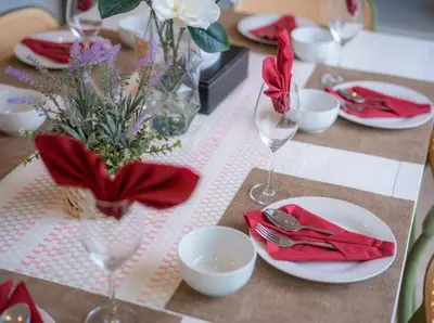 a table with red napkins and plates and wine glasses at \u6cf0\u56fd\u666e\u5409\u5c9bYona\u8c6a\u534e\u6d77\u8fb9\u56db\u5367\u5ba44\u53f7 in Ban Bang La