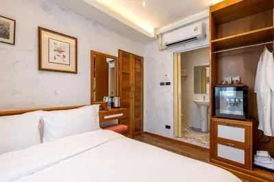 a hotel room with a bed and a television at Twelve 8 Boutique House in Phuket Town