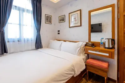 a bedroom with a bed and a desk with a mirror at Twelve 8 Boutique House in Phuket Town