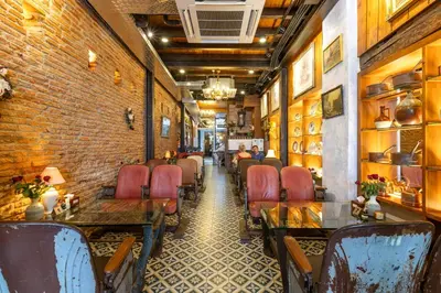 a restaurant with tables and chairs and a brick wall at Twelve 8 Boutique House in Phuket Town