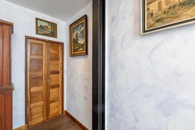 a hallway with a door and paintings on the wall at Twelve 8 Boutique House in Phuket Town