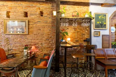 a restaurant with a brick wall and a table and chairs at Twelve 8 Boutique House in Phuket Town