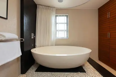a white bath tub in a bathroom with a window at The Residence Bangtao Villa 216 in Bang Tao Beach