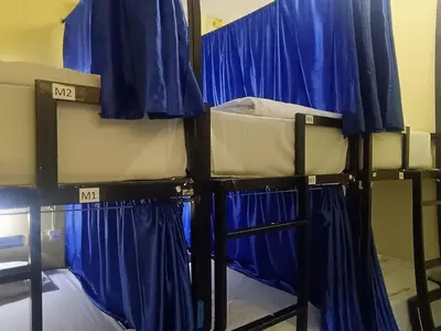 two bunk beds with blue curtains on them at 3Plus1 Hostel Patong in Patong Beach