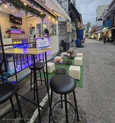 a bar with stools on the side of a street at 3Plus1 Hostel Patong in Patong Beach