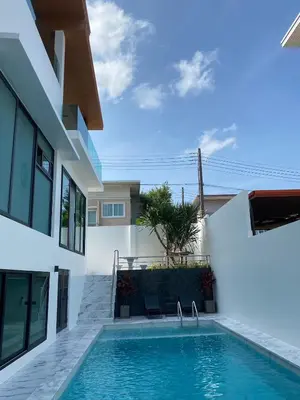 a swimming pool in front of a house at Mountain breeze villa phuket in Ban Bang Khu