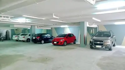 a parking garage with several cars parked in it at At the tree by fatimah Rawai R315 in Rawai Beach