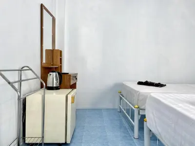 a small room with two beds and a mirror at Mini Thai Guesthouse Patong in Patong Beach