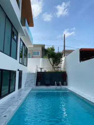 a swimming pool in front of a house at Mountain breeze villa phuket in Ban Bang Khu