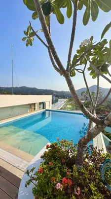a swimming pool with a palm tree and a building at Fantasea Condo Kamala beach 1BR apart B1 in Kamala Beach