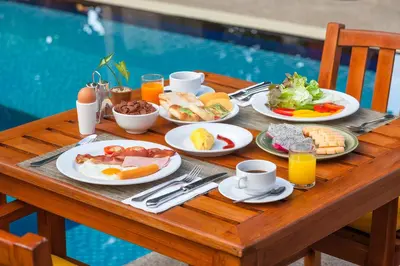 a table with plates of breakfast food on it at Phuket Moonlit Bay Seaview Resort & Spa in Phuket Town