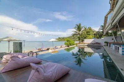 a hotel swimming pool with pillows and the ocean at Phuket Moonlit Bay Seaview Resort & Spa in Phuket Town