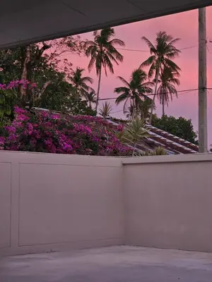 a view of a garden with palm trees and purple flowers at Leivi Villa 3 bedrooms in Rawai Beach