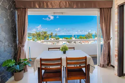 a dining room with a table and a view of the ocean at PatongTower\u6b65\u884c\u76f4\u8fbe\u6d77\u6ee9\u9ad8\u901fwifi605S in Patong Beach