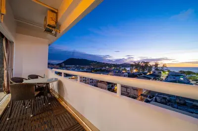 a balcony with a table and chairs and a view of the ocean at PatongTower\u6b65\u884c\u76f4\u8fbe\u6d77\u6ee9\u9ad8\u901fwifi605S in Patong Beach