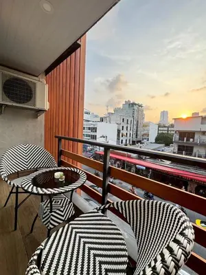 a balcony with two chairs and a table with a view at Aspira Central Patong in Patong Beach