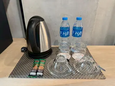 a coffee pot and two bottles of water and glasses at Aspira Central Patong in Patong Beach
