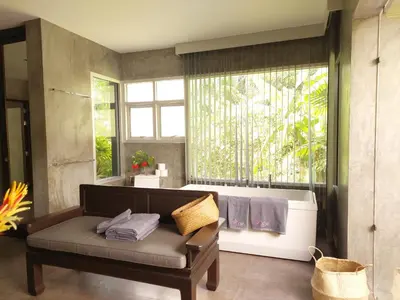 a living room with a couch and a large window at 11 - Peaceful Escape on Naiyang Beach in Nai Yang Beach