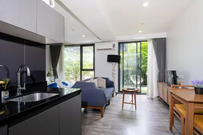 a kitchen with a sink and a living room at Patong city-center pool cozy condo in Patong Beach