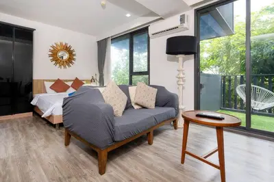 a bedroom with a couch and a bed and a table at Patong city-center pool cozy condo in Patong Beach