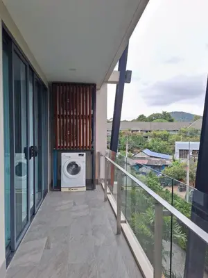 a balcony of a house with a washing machine at At the tree by fatimah Rawai 408 in Rawai Beach