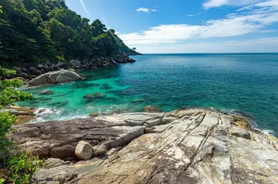 a view of the ocean from a rocky shore at The Aquila Villa in Kamala Beach