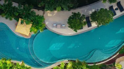 an overhead view of a large swimming pool with palm trees at Dcondo reef 99 in Kathu
