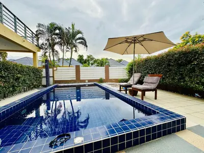 a swimming pool with a chair and an umbrella at Villa 3bd & pool - Rawai - Nai Harn in Rawai Beach