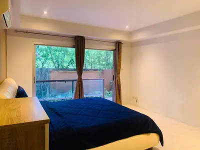 a bedroom with a blue bed and a window at Rawai Condominium By Wijitra in Phuket Town
